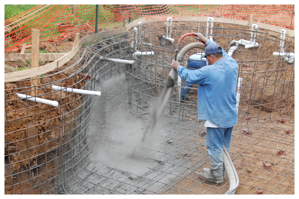 Concrete pool construction using rebar and sprayed gunite, showing how traditional inground pools are built before interior finishing begins.