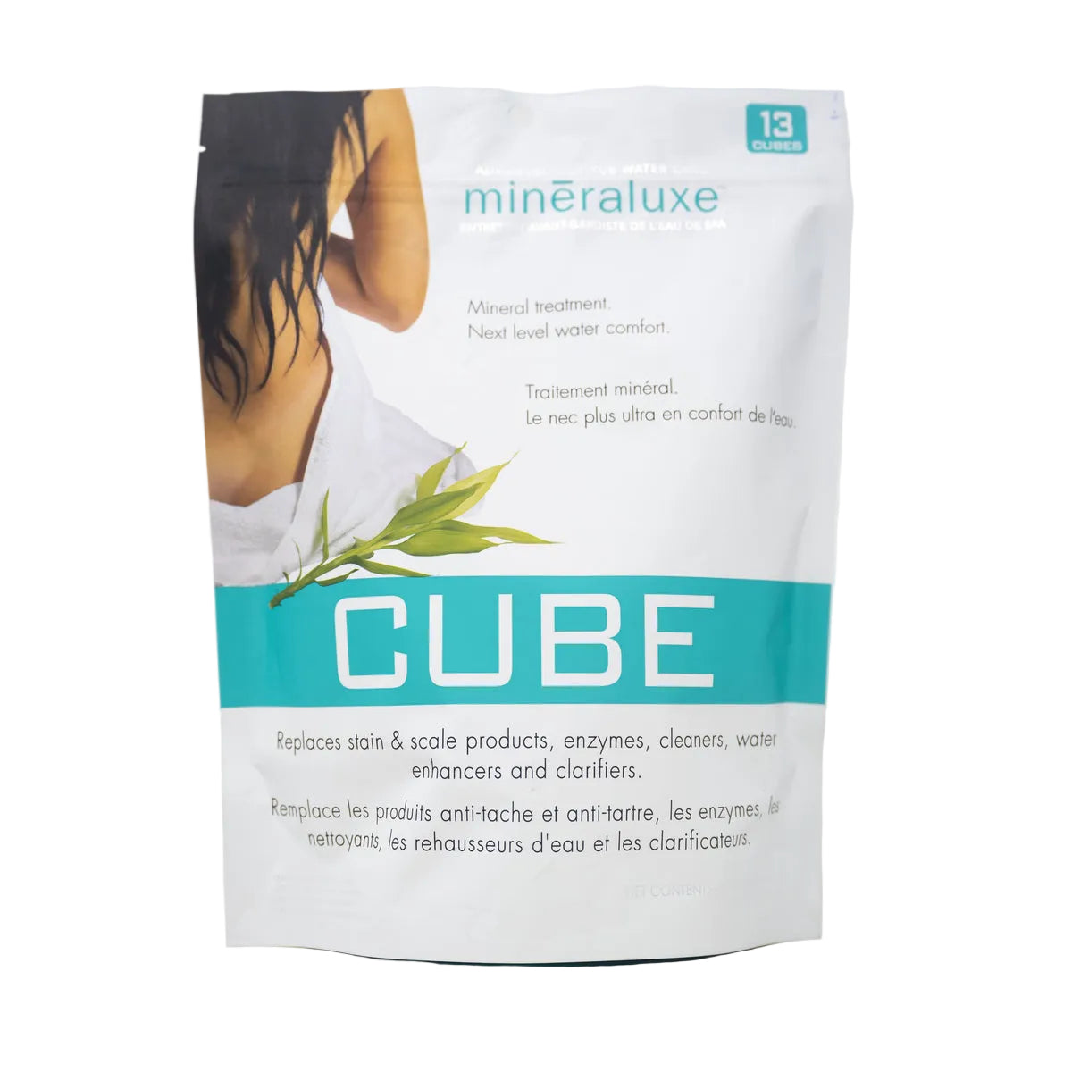 A stand-up pouch of minéraluxe CUBE mineral treatment, featuring a white background with a teal band, a photo of a woman's back, and green leaves on the front.
